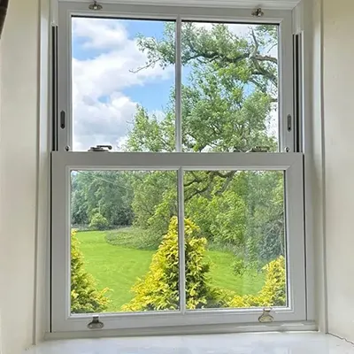 A window with a view of a green field.