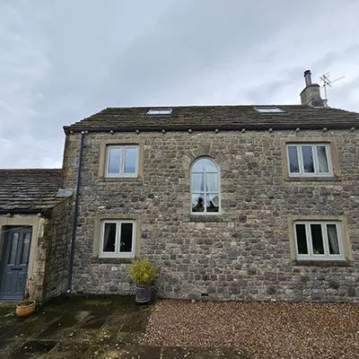 A stone building with a blue door and windows.