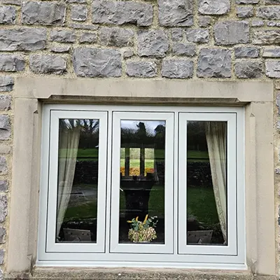 A cat sitting on a window sill next to a window.