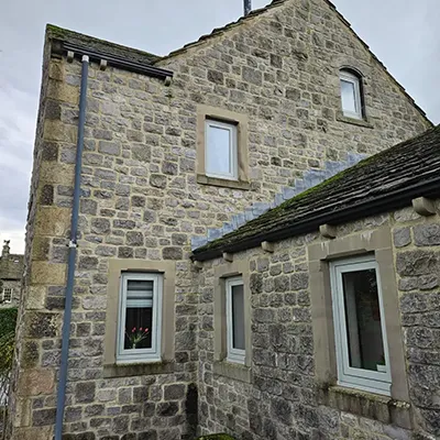 A stone building with a clock tower on top of it.
